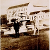 Dois cavalheiros fazendo "pose" em frente ao chafariz da Praça Getúlio Vargas. Ao fundo o prédio antigo do Colégio Sagrado Coração de Jesus, conhecido como Colégio das Irmãs.